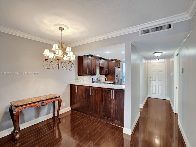 kitchen with a notable chandelier, dark wood-type flooring, stainless steel appliances, and decorative light fixtures