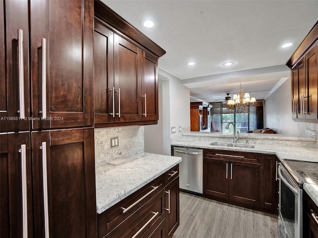 kitchen with appliances with stainless steel finishes, sink, light hardwood / wood-style flooring, a chandelier, and light stone counters