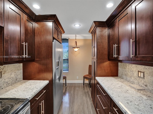 kitchen featuring decorative light fixtures, light stone countertops, tasteful backsplash, stainless steel fridge, and dark hardwood / wood-style floors