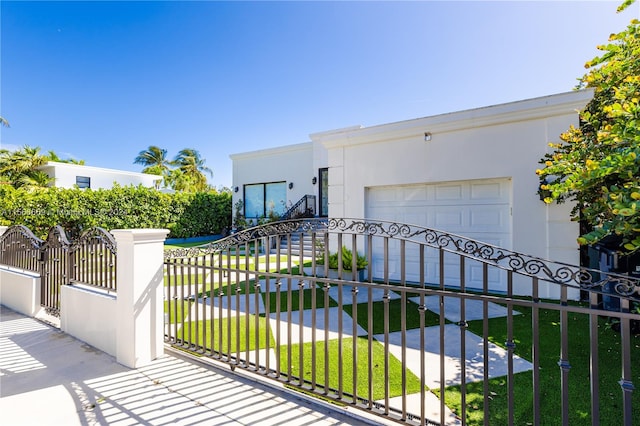 view of gate with a yard and a garage