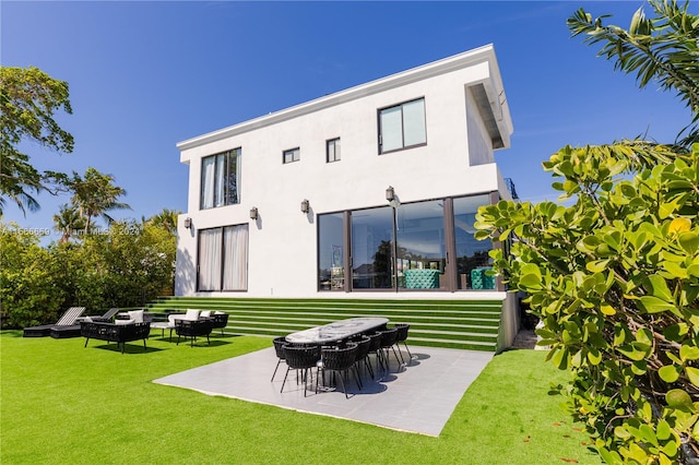 back of house featuring a patio, a fire pit, and a lawn