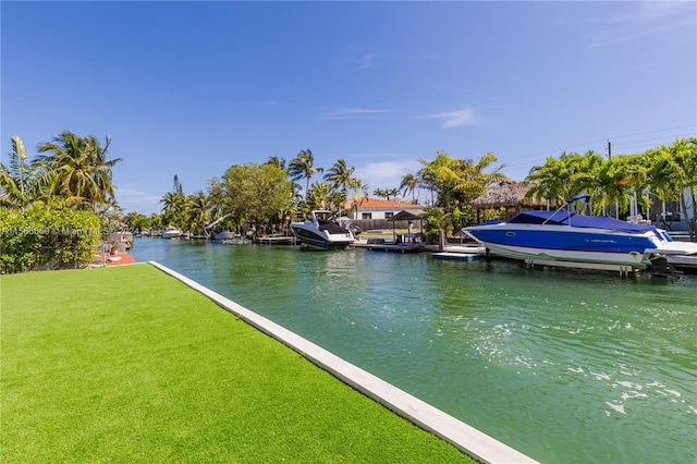 view of dock with a lawn and a water view