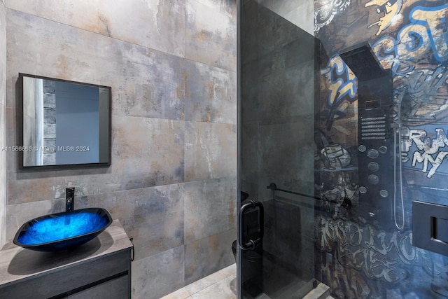 bathroom featuring vanity and tile walls