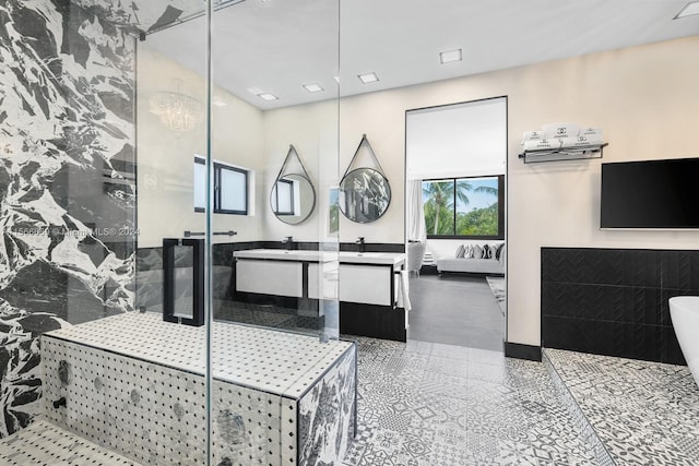 bathroom with an enclosed shower, tile walls, and vanity