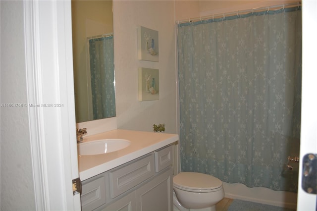 bathroom with toilet and vanity with extensive cabinet space