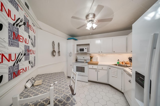 kitchen featuring tasteful backsplash, ceiling fan, white appliances, light tile floors, and white cabinets