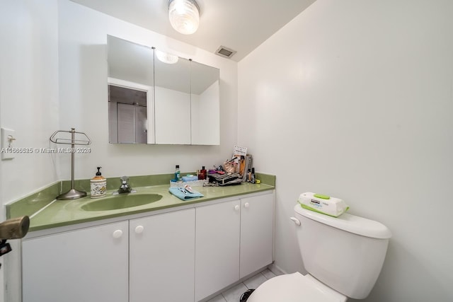 bathroom featuring tile floors, toilet, and vanity