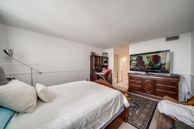 carpeted bedroom featuring a textured ceiling