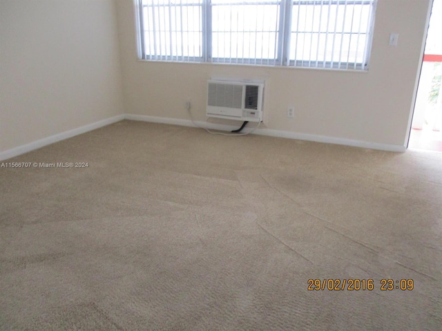 carpeted spare room featuring a wall mounted air conditioner