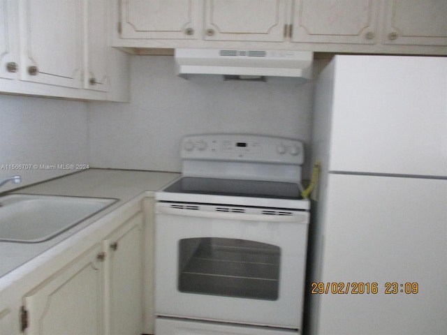 kitchen featuring white cabinets, sink, white appliances, and wall chimney exhaust hood