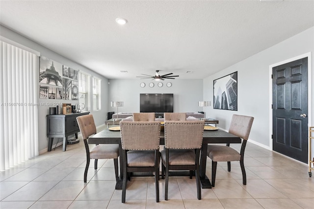 tiled dining room with a textured ceiling and ceiling fan