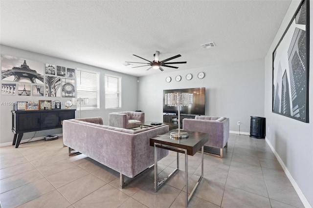 tiled living room with ceiling fan and a textured ceiling