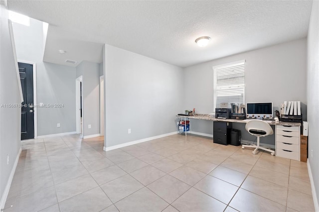 home office featuring built in desk, a textured ceiling, and light tile patterned floors