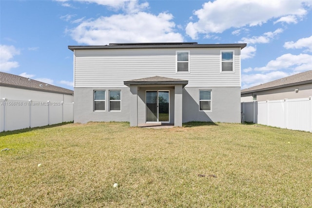 112 Towns, Haines City, FL 33844 - rear view of property featuring a fenced backyard, a lawn, and stucco siding