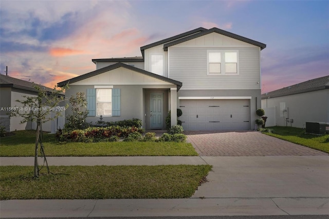 112 Towns, Haines City, FL 33844 - traditional-style house with stucco siding, an attached garage, decorative driveway, and a lawn