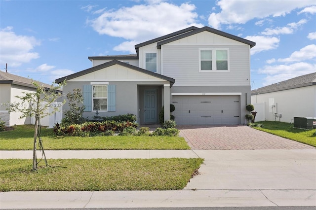 view of front facade featuring a garage, central AC, and a front yard