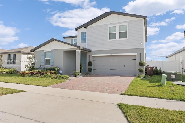 112 Towns, Haines City, FL 33844 - view of front of house featuring fence, a front lawn, board and batten siding, an attached garage, and decorative driveway