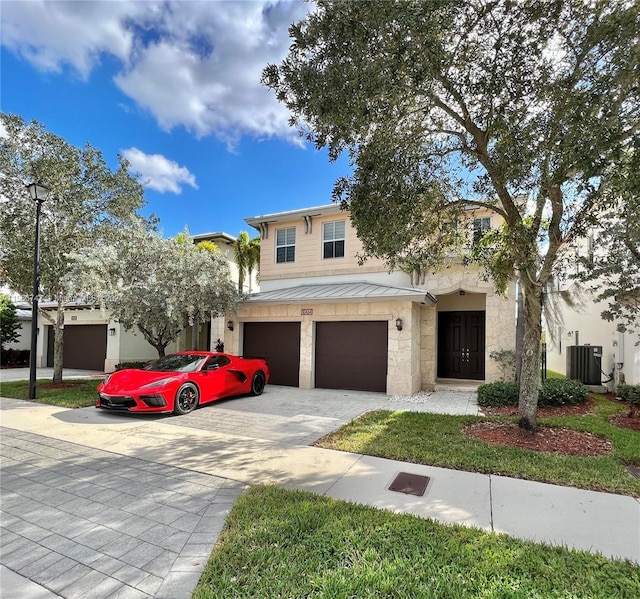 view of front of property with central AC unit and a garage