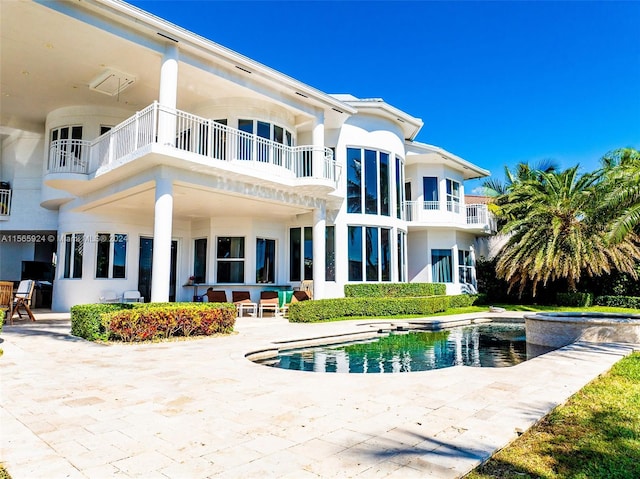 back of property with a balcony and a patio