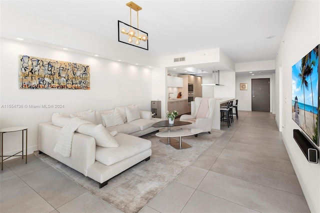 tiled living room featuring a notable chandelier