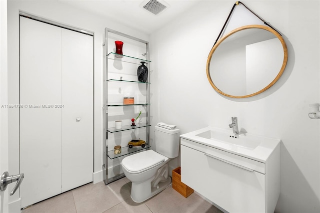 bathroom with tile flooring, toilet, and vanity