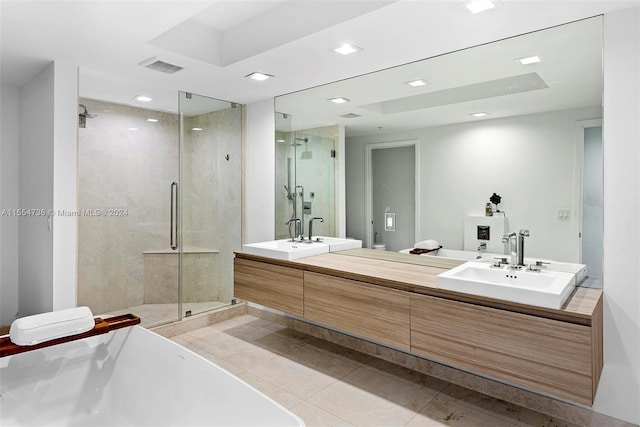 bathroom with tile flooring, a shower with shower door, and double sink vanity