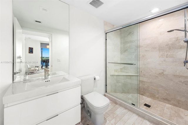 bathroom with toilet, tile floors, a shower with shower door, and large vanity