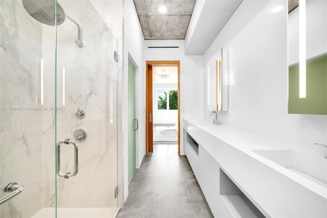 bathroom featuring concrete flooring, vanity, and a shower with shower door