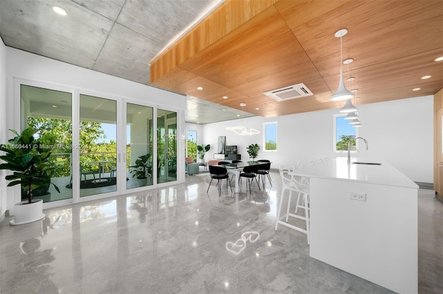 dining room with concrete flooring, plenty of natural light, and sink