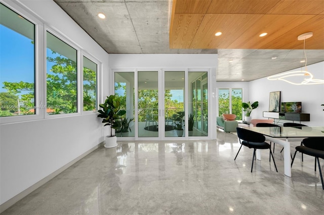 sunroom / solarium featuring an inviting chandelier