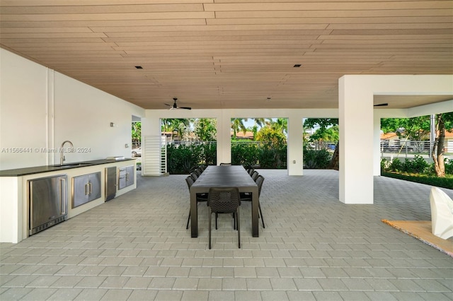 view of patio featuring an outdoor kitchen, ceiling fan, and sink