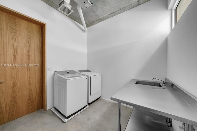 clothes washing area featuring washer and clothes dryer and sink