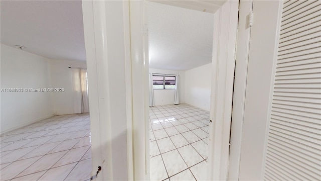 hall featuring light tile flooring