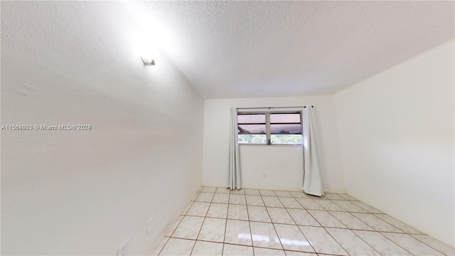 tiled spare room with a textured ceiling