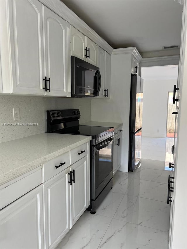 kitchen with white cabinets, backsplash, light tile floors, and black appliances