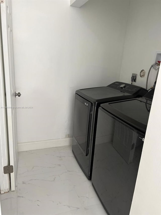 laundry room with hookup for a washing machine, hookup for an electric dryer, washing machine and clothes dryer, and light tile flooring