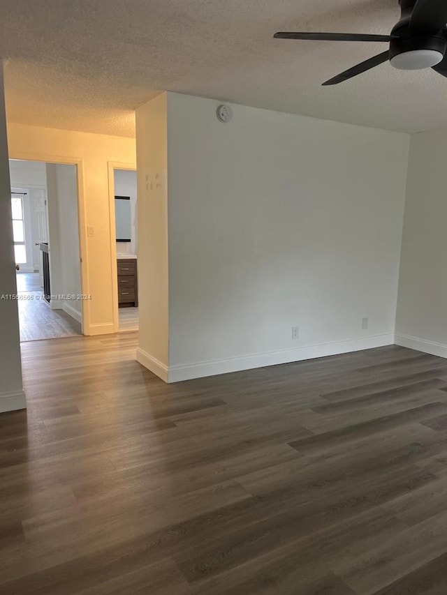 spare room featuring ceiling fan, dark hardwood / wood-style floors, and a textured ceiling