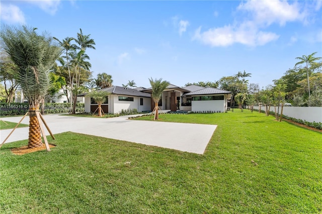 exterior space featuring concrete driveway, a yard, and fence