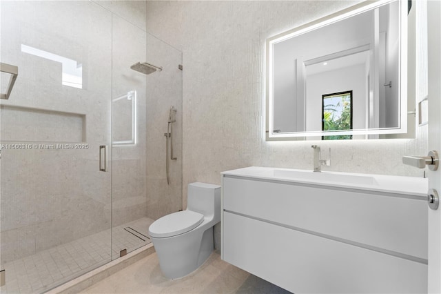 full bath featuring toilet, tile patterned floors, vanity, a shower stall, and tile walls