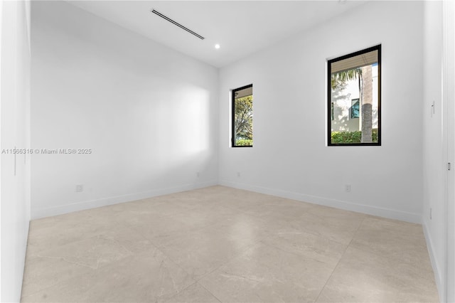 unfurnished room with recessed lighting, plenty of natural light, and baseboards