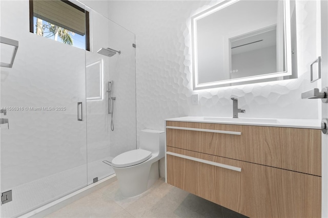 bathroom featuring toilet, a stall shower, vanity, and tile patterned floors