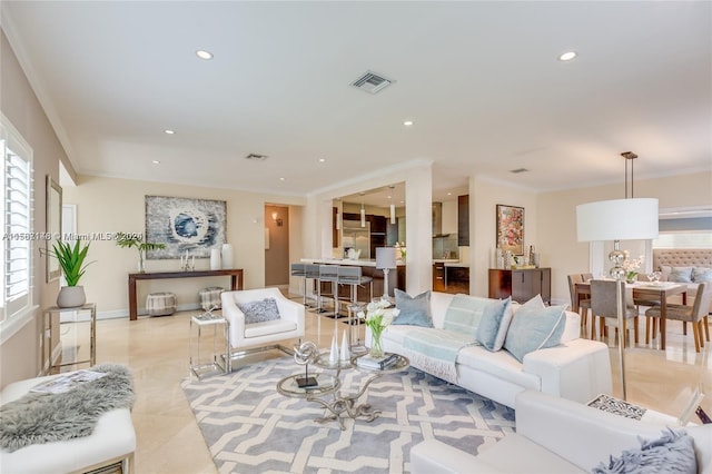 living room with crown molding, light tile flooring, and plenty of natural light