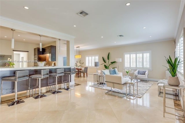 tiled living room with crown molding and sink