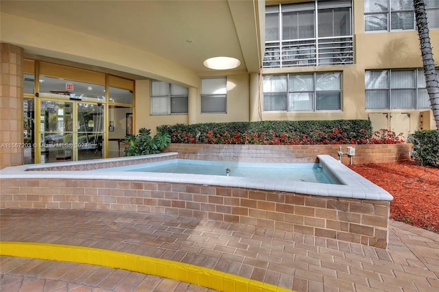 view of swimming pool featuring a jacuzzi