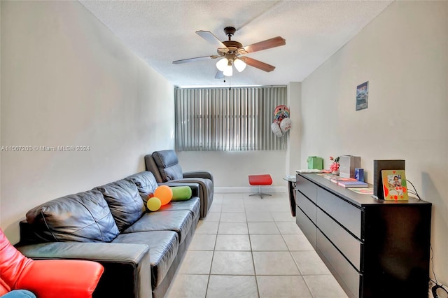 living room featuring ceiling fan, a textured ceiling, and light tile flooring