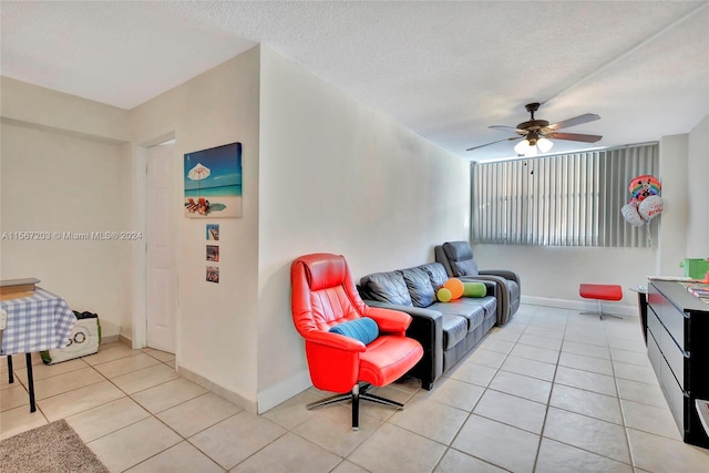 tiled living room featuring ceiling fan and a textured ceiling