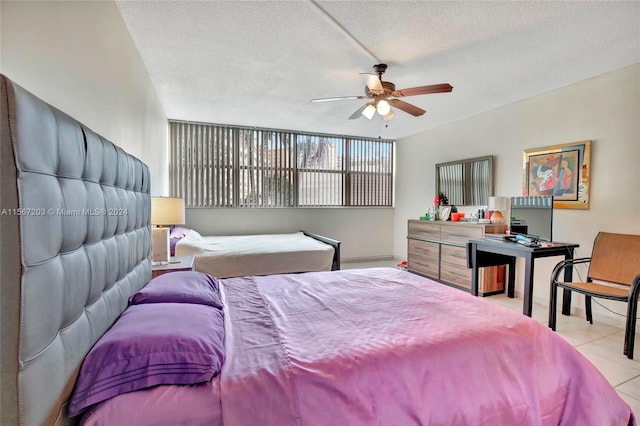 bedroom featuring ceiling fan, a textured ceiling, and light tile flooring