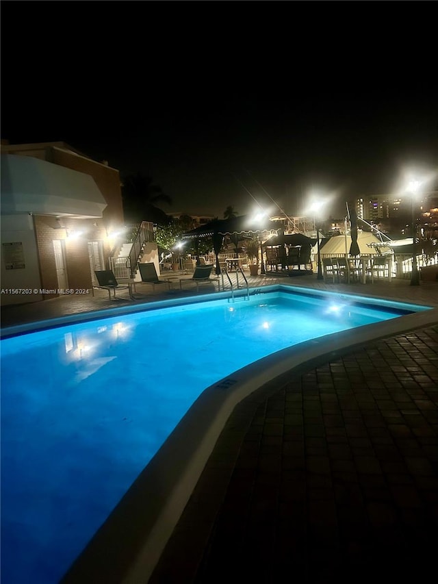 pool at night with a patio area