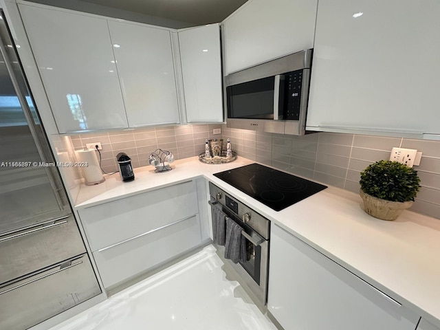 kitchen featuring white cabinetry, decorative backsplash, and appliances with stainless steel finishes