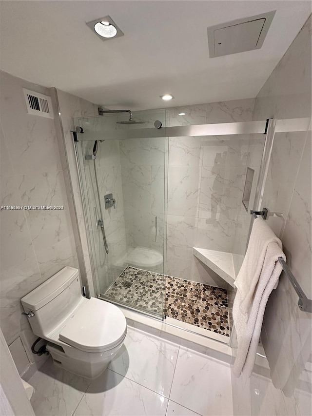 bathroom featuring a shower with shower door, toilet, and tile walls